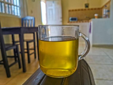 Glass or cup pot with hot ginger tea on a wooden table in Mexico.