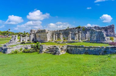 Antik Tulum, Tulum Meksika 'daki tropikal doğal orman palmiyesi ve deniz manzarasında tapınak kalıntıları ve eserlerle Maya bölgesini harabeye çeviriyor..