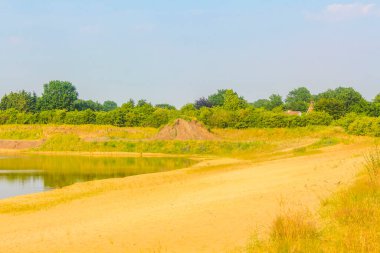 Hemmoor Hechthausen Cuxhaven Aşağı Saksonya Almanya 'sında kum ve kumlu tepe ormanı ve doğa ile güzel nehir su plajı.