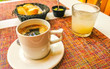 Playa del Carmen Quintana Roo Mexico 'daki PapaCharly Papa Charly restoranında bir fincan siyah americano kahveli ekmek suyu yemeği ve içecek..