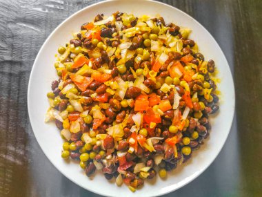 Vegetable dish soup with beans peas potatoes onions tomato and garlic on a white plate bowl with fork or spoon in Mexico.