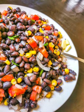 Vegetable dish soup with beans peas potatoes onions tomato and garlic on a white plate bowl with fork or spoon in Mexico.
