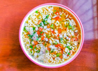 Erişte çorbası hazır pembe kase içinde kahverengi tahta masa arkasında Playa del Carmen Quintana Roo Mexico 'da.