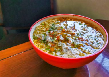 Erişte çorbası hazır pembe kase içinde kahverengi tahta masa arkasında Playa del Carmen Quintana Roo Mexico 'da.