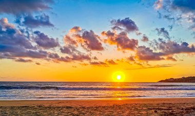 Sahilde sarı turuncu ve altın sarısı günbatımı ve Zicatela Puerto Escondido Oaxaca 'da tropikal doğada büyük dalga manzarası..