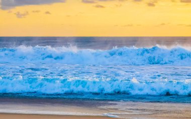 Sahilde sarı turuncu ve altın sarısı günbatımı ve Zicatela Puerto Escondido Oaxaca 'da tropikal doğada büyük dalga manzarası..