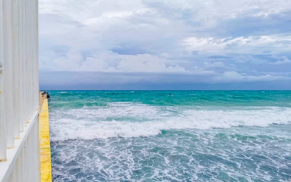 Hurricane 2021 thunderstorm tropical storm with the view on high strong waves wind and dark clouds from the pier Muelle Constituyentes in Playa del Carmen Quintana Roo Mexico.