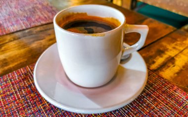 Glass cup of americano black coffee with spoon and plate on table food and drink in the restaurant PapaCharly Papa Charly in Playa del Carmen Quintana Roo Mexico.