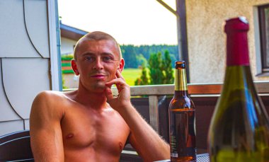 Braunlage Harz Goslar Aşağı Saksonya Almanya 'sındaki dağların balkonunda bira ve şarap içen adam..