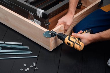 Üniformalı bir işçi tavan arasındaki merdiven boşluğuna metal bir destek yerleştirir..