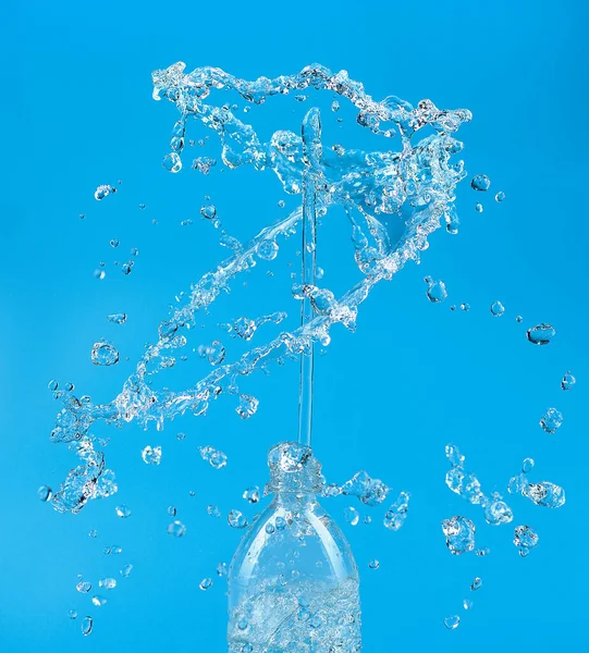 青い背景にPetボトルから脱出する滴と水のスプラッシュ 純水の概念 — ストック写真