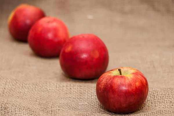 Red apples on sackcloth background — Stock Photo, Image