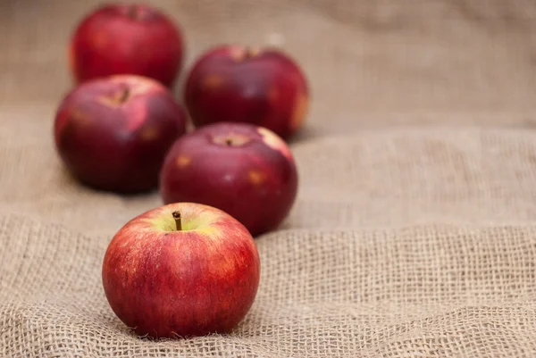 Red apples on sackcloth background — Stock Photo, Image