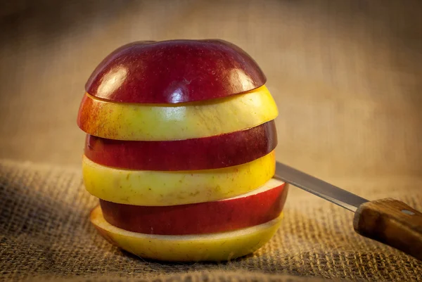 Slices of red and yellow apples with knife — Stock Photo, Image
