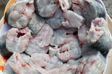 Restoranda öğle yemeği hazırlamak için kepekli çiğ et küçük parçalara ayrıldı. Çiğ balık eti pazarda yakın çekim görüntüsü.