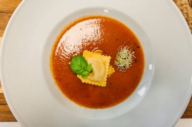 Domates çorbası ya da Ravioli soslu gazpacho çorbası ve ahşap kırsal bir masada fesleğen.. 