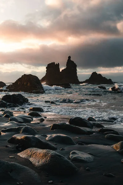 Kuzey Tenerife sahilinde gün batımında kumlu ve taşlı güzel bir sahil manzarası. Kanarya Adaları 'nda altın güneşli Atlantik dalgalı okyanus. Playa de Benijo 'nun İspanya' daki koyu renkli fotoğrafı.