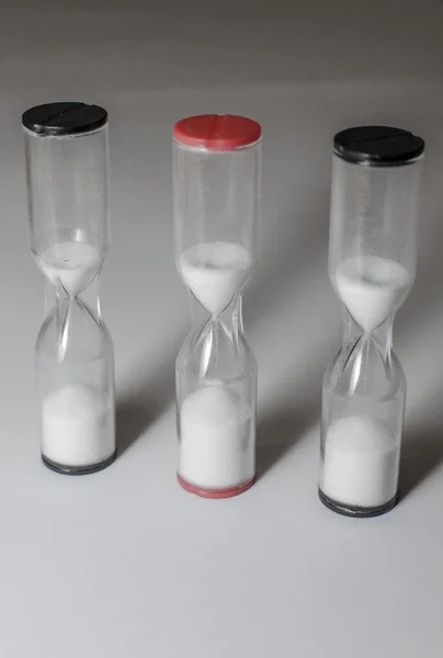 Bir satırda üç çalışan hourglasses — Stok fotoğraf