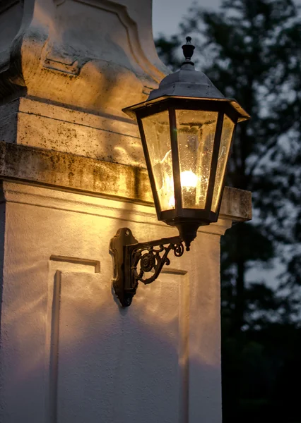 Old faint Lantern beneath a gate — Stock Photo, Image