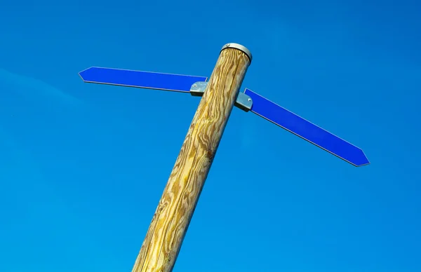 Wooden pole with two blue direction arrows — Stock Photo, Image