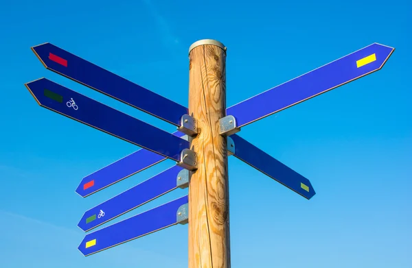 Palo in legno con numerose frecce di direzione — Foto Stock