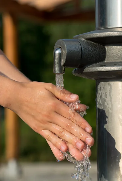 Мытье рук под родником с чистой и пресной водой — стоковое фото