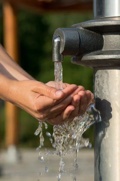 Attraper l'eau fraîche et fraîche d'une source à mains nues — Photo