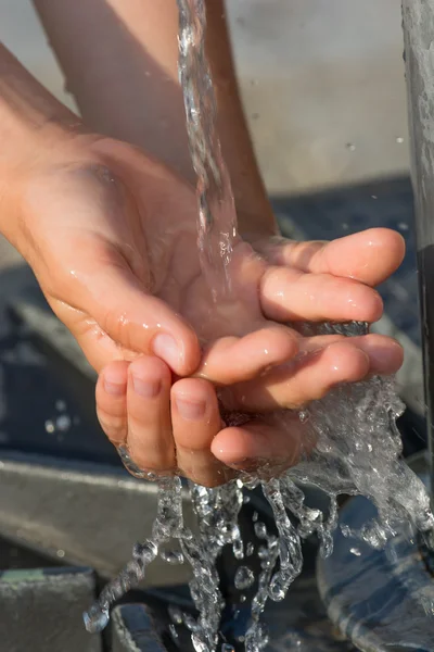 Frisches und kühles Wasser aus einer Quelle mit den Händen auffangen — Stockfoto