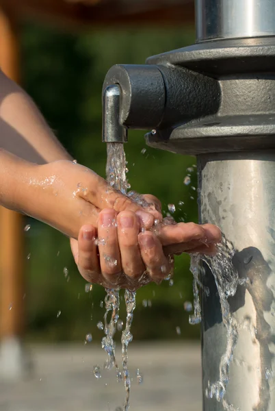 Attraper l'eau fraîche et fraîche d'une source à mains nues — Photo