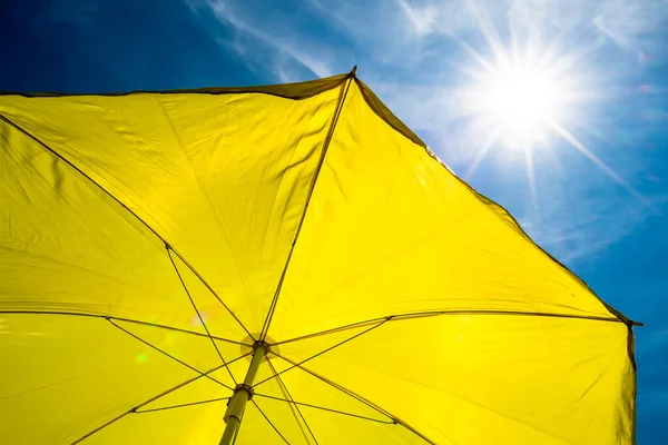 明るい太陽と青い空と黄色の傘 — ストック写真