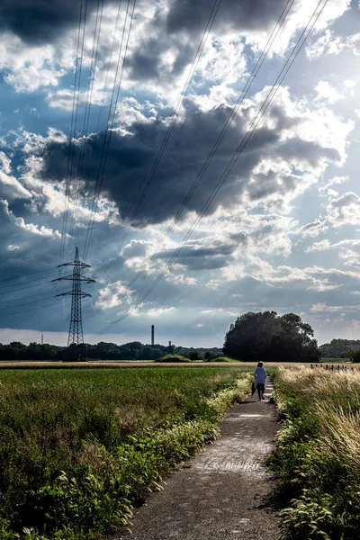 Old Woman Walks Gravel Path Rural Landscape Heavy Rainclouds Energy — Foto de Stock