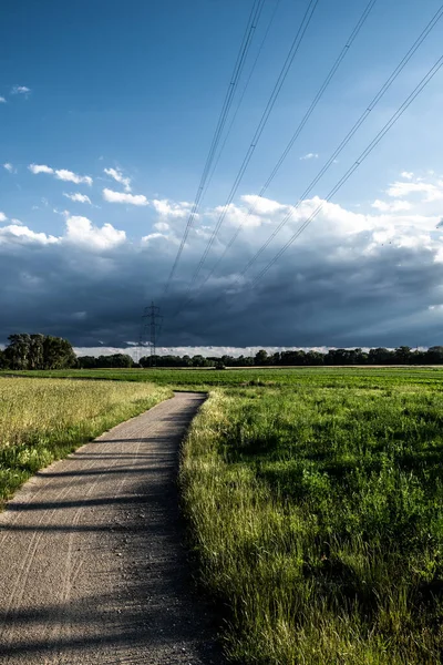 High Electricity Pylon With Wires In Rural Landscape With Agricultural Areas