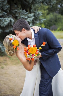 gelinlik içinde öpüşme genç bir çift. Gelin holding buket çiçek