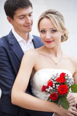 gelinlik içinde öpüşme genç bir çift. holding ile kırmızı gül buketi gelin