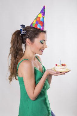 esmer kadın doğum günü şapkası pasta mumu üfleme