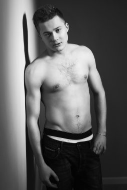 gömleksiz yakışıklı adam fit vücut kapalı bir duvara yaslansın. siyah ve beyaz