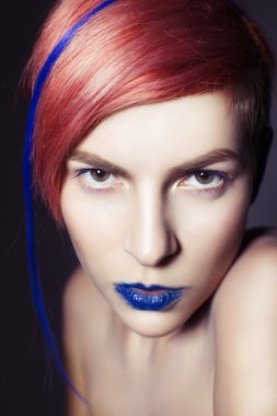 mavi göz farı, mavi kulakları ve üzerinde mavi damarlı kamera ve elleri yakın yüzüne bakarak pembe saçlı genç kişi. siyah arka plan