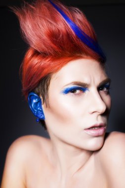 mavi göz farı, mavi kulakları ve üzerinde mavi damarlı kamera ve elleri yakın yüzüne bakarak pembe saçlı genç kişi. siyah arka plan