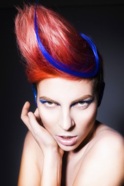 mavi göz farı, mavi kulakları ve üzerinde mavi damarlı kamera ve elleri yakın yüzüne bakarak pembe saçlı genç kişi. siyah arka plan