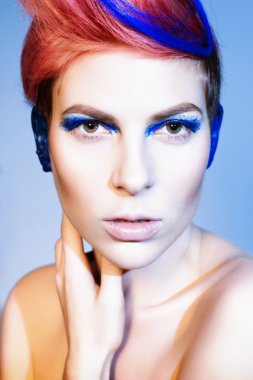 mavi göz farı, mavi kulakları ve üzerinde mavi damarlı kamera ve elleri yakın yüzüne bakarak pembe saçlı genç kişi. siyah arka plan