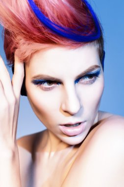 mavi göz farı, mavi kulakları ve üzerinde mavi damarlı kamera ve elleri yakın yüzüne bakarak pembe saçlı genç kişi. siyah arka plan