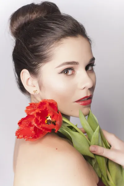 Mooie brunette vrouw portret met tulpen en rode lippenstift — Stockfoto