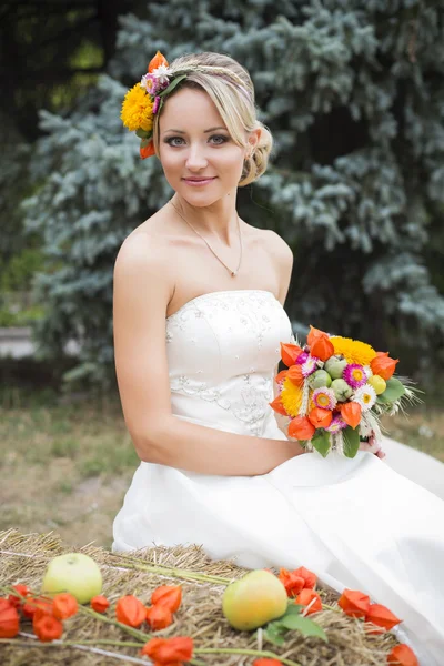 Belle mariée en robe de mariée blanche tenant bouquet de fleurs et souriant — Photo