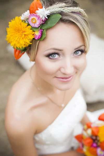 Beautiful bride in white wedding dress holding flower bouquet and smiling