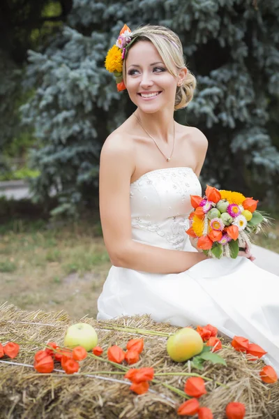 Красивая невеста в белом свадебном платье с цветочным букетом и улыбкой — стоковое фото