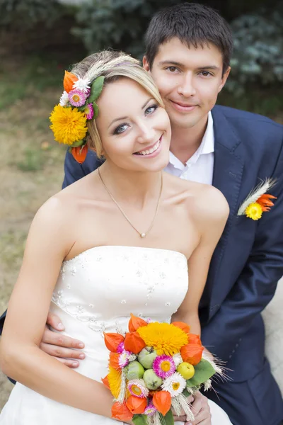 Jeune couple embrassant en robe de mariée. Mariée tenant bouquet de fleurs — Photo