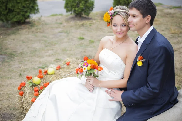 Jeune couple embrassant en robe de mariée. Mariée tenant bouquet de fleurs — Photo