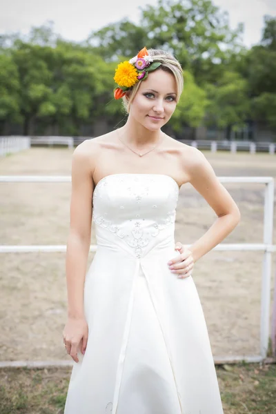 Belle mariée en robe de mariée blanche tenant bouquet de fleurs et souriant — Photo