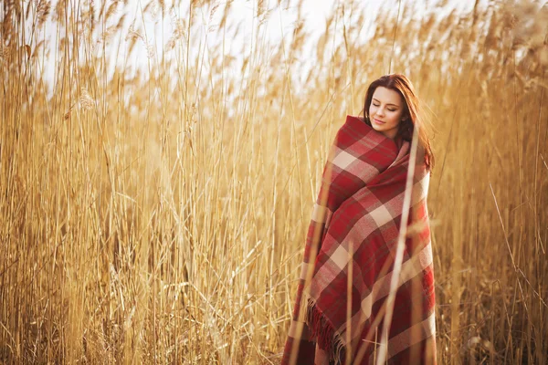 Brunette vrouw buitenshuis in selectievakje patroon plaid glimlachen en kijken naar camera. kopie ruimte — Stockfoto