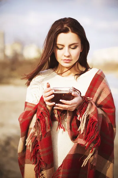 Brunette femme en plein air à carreaux modèle à carreaux boire du thé et regarder vers le bas près du lac — Photo